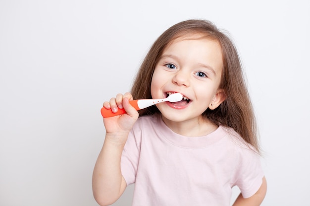 Dulce bebé se cepilla los dientes con una sonrisa Salud dental Ojos azules y cabello rubio Colores neutros Salud dental Cuidando al bebé Higiene