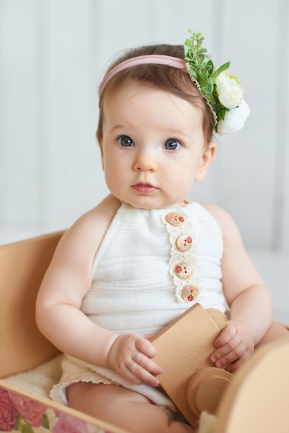 Dulce bebé gracioso en sombrero con flores. EasterCute niña de 6 meses con sombrero de flores.