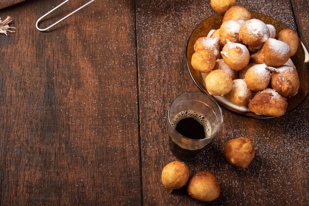 Dulce brasileño llamado bolinho de Chuva, cubierto de azúcar sobre madera rústica