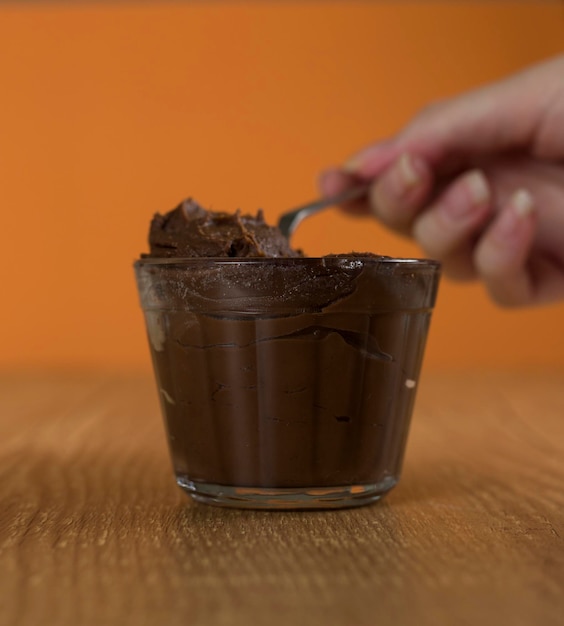 Foto dulce de chocolate brasileño llamado brigadeiro en maceta sobre fondo de escritorio de madera versión vegana