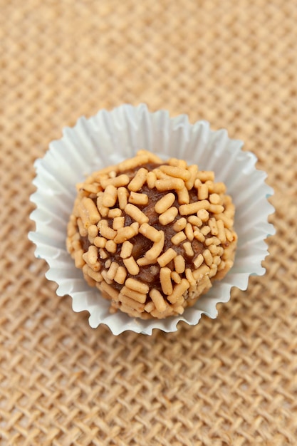 Foto dulce conocido en brasil como brigadeiro de amendoim aislado en fondo de yute