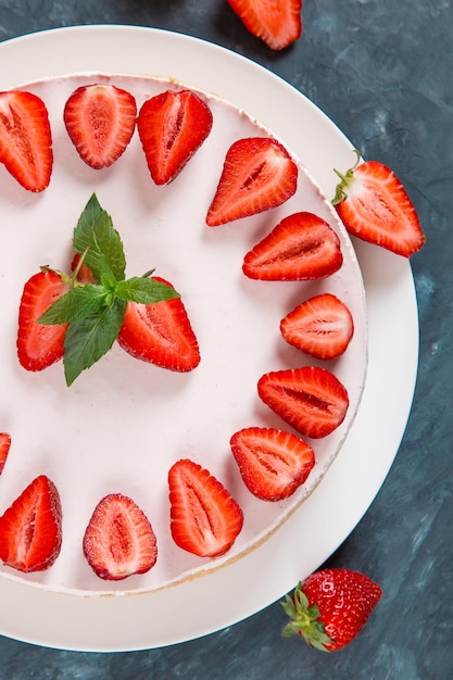 Dulce desayuno delicioso pastel de queso con fresas frescas y menta receta casera sin hornear en una mesa de piedra azul oscuro Espacio de copia