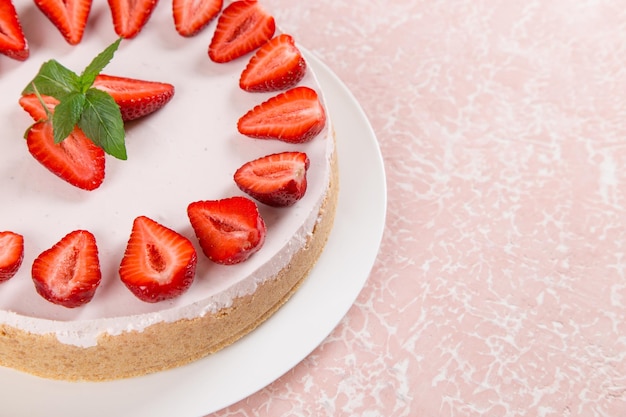 Dulce desayuno delicioso pastel de queso con fresas frescas y menta receta casera sin hornear en una mesa de piedra rosa Espacio de copia