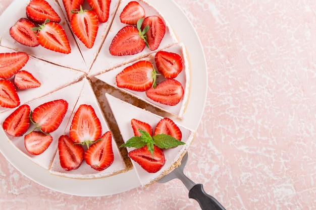 Dulce desayuno delicioso pastel de queso con fresas frescas y menta receta casera sin hornear en una mesa de piedra rosa Espacio de copia