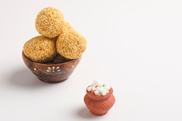 Foto dulce indio para el festival tradicional makar sankranti: rajgira laddu hecho de semilla de amaranth en bowl sobre fondo blanco.