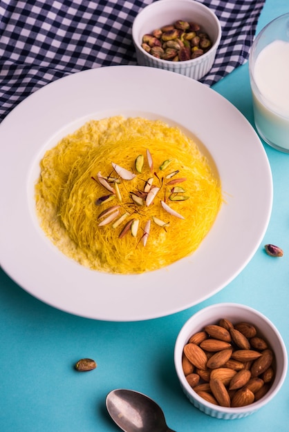 Dulce indio kesar sutarfeni o sutar feni o firni o seviyan o laccha, rallado, copos de harina de arroz tostado en ghee, mezclado con azúcar derretido para formar un algodón de azúcar, con pistacho y almendras