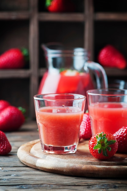 Dulce jugo de fresa en la mesa de madera