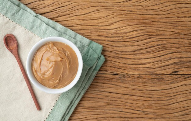 Dulce de leche cremoso tradicional brasileño Doce de leite sobre mesa de madera con espacio para copiar