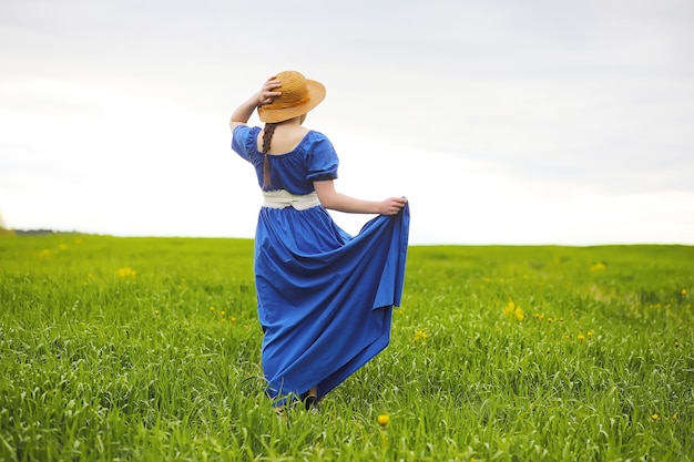 Una dulce niña en el campo en un paseo por la tarde soleada