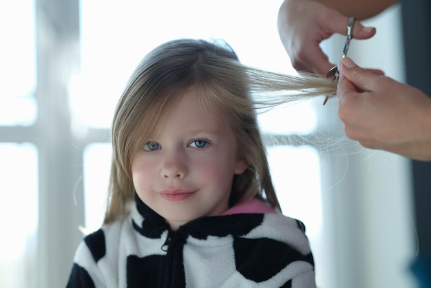 Dulce niña cortando un mechón de cabello