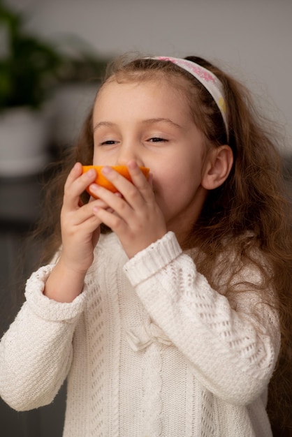 Una dulce niña una naranja Alimentación saludable Familia Fruta fresca