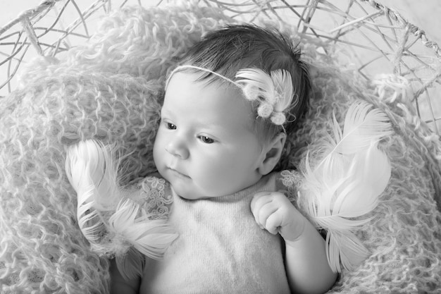Dulce niña recién nacida con los ojos abiertos Niña recién nacida de 3 semanas de edad acostada en una canasta con cuadros de punto Retrato de niña bonita recién nacida Imagen de primer plano