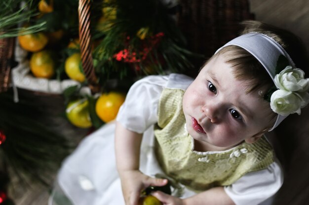 Dulce niña en un vestido con canasta de navidad