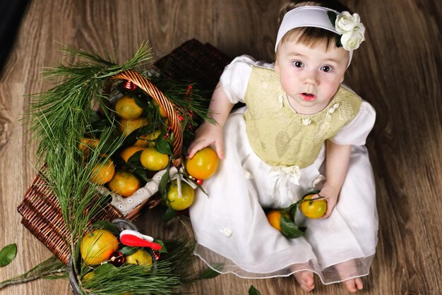 Dulce niña en un vestido con canasta de navidad