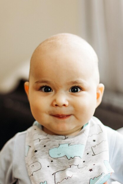 Dulce niñito de mejillas regordetas y ojos grandes. Retrato de niño sonriente feliz