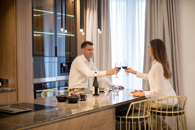 Dulce pareja con una cena romántica en la cocina de lujo