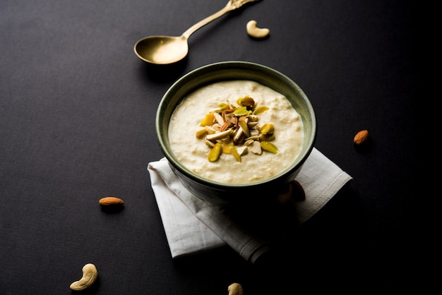 Dulce Rabdi o Lachha Rabri o basundi, elaborado con leche pura aderezada con frutos secos. Servido en un bol sobre fondo de mal humor. Enfoque selectivo