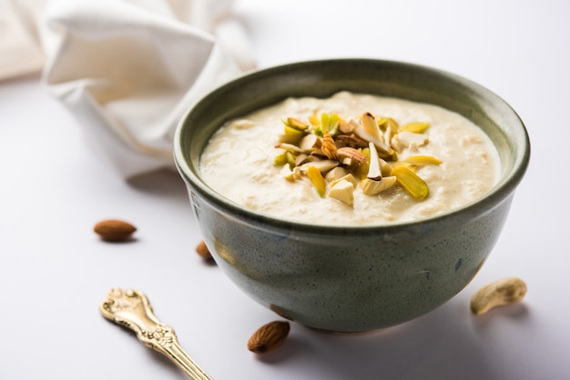 Dulce Rabdi o Lachha Rabri o basundi, elaborado con leche pura aderezada con frutos secos. Servido en un bol sobre fondo de mal humor. Enfoque selectivo