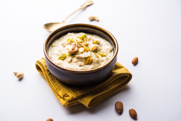 Dulce Rabdi o Lachha Rabri o basundi, elaborado con leche pura aderezada con frutos secos. Servido en un bol sobre fondo de mal humor. Enfoque selectivo