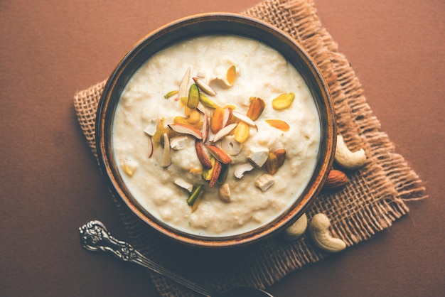 Dulce Rabdi o Lachha Rabri o basundi, elaborado con leche pura aderezada con frutos secos. Servido en un bol sobre fondo de mal humor. Enfoque selectivo