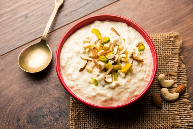 Dulce Rabdi o Lachha Rabri o basundi, elaborado con leche pura aderezada con frutos secos. Servido en un bol sobre fondo de mal humor. Enfoque selectivo