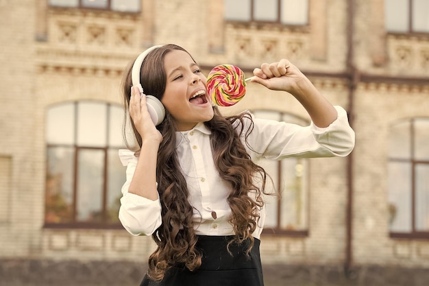 Dulce remix Niño feliz cantando dulces dulces mic Infancia feliz Niño niño auriculares sosteniendo piruleta dulce Niño feliz con dulces al aire libre divirtiéndose Calorías y energía Colegiala merece postre