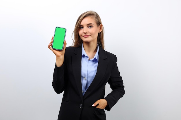 Foto una dulce secretaria muestra una maqueta de la pantalla de su teléfono inteligente verticalmente