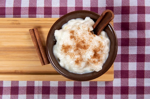 Dulce tradicional de las fiestas de junio de Brasil hecho de maíz blanco con coco y leche condensada y espolvoreado con canela