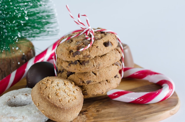 Dulces con adornos navideños y mesa de cocina de madera de olivo.