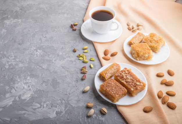 Dulces árabes tradicionales y una taza de café sobre un fondo de hormigón gris. Vista lateral, copia espacio.