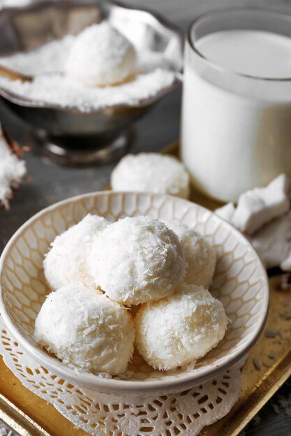 Dulces caseros en copos de coco y coco fresco sobre fondo claro