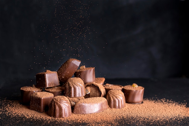 Foto dulces de chocolate de alto ángulo con cacao en polvo