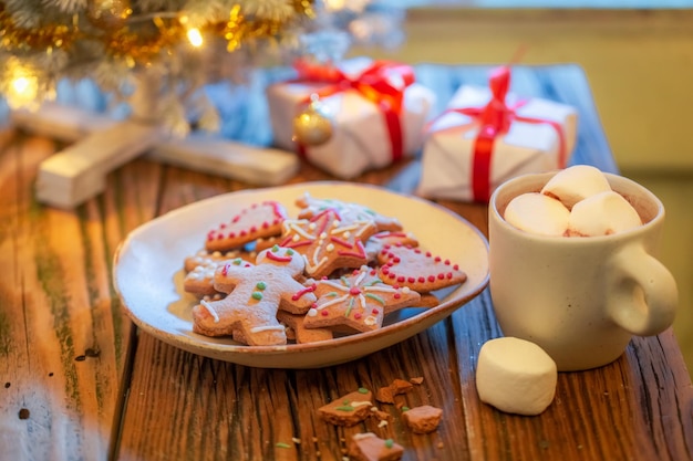 Dulces galletas de jengibre bajo el árbol de Navidad con regalos