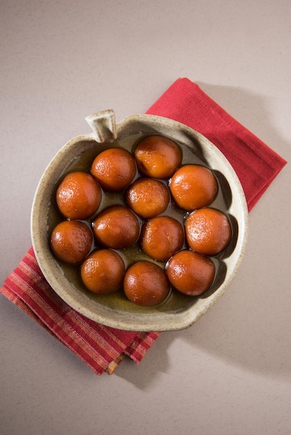 Dulces indios Gulab Jamun servidos en un cuenco de cerámica redondo