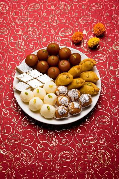 Los dulces indios en un plato incluyen Gulab Jamun, Rasgulla, kaju katli, morichoor o Bundi Laddu, Gujiya o Karanji para la celebración de diwali