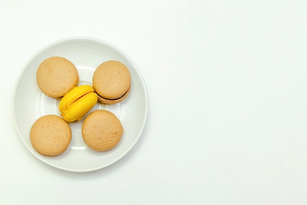 Dulces macarons de chocolate y limón en un plato aislado sobre fondo blanco pastelería postres sabrosos azúcar foodcopy spacetop view