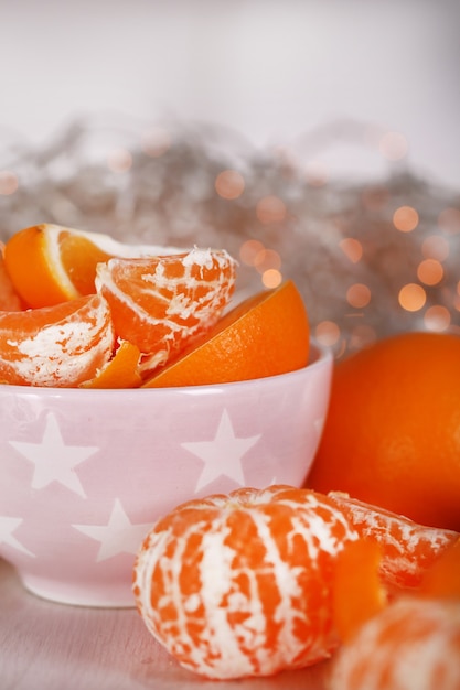 Foto dulces mandarinas y naranjas en la mesa en un tazón en la habitación