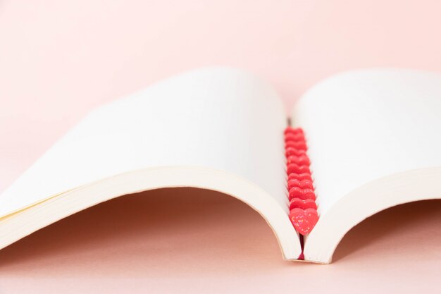 Dulces mini corazones en rojo en un libro