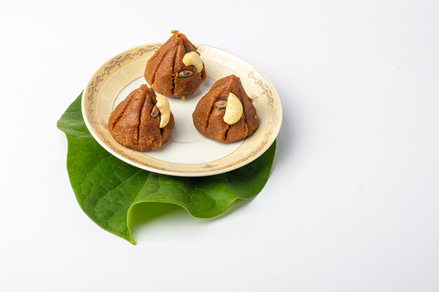 Dulces modak indios tradicionales hechos en casa sobre fondo blanco y placa