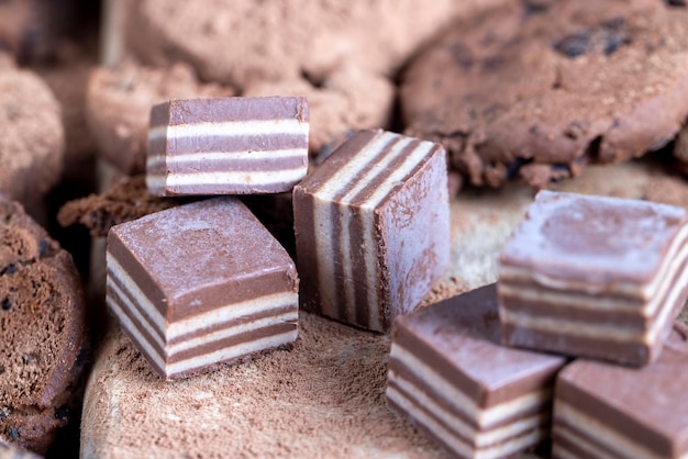 Dulces multicapa hechos de capas de crema y chocolate con diferentes sabores sabor mezclado de dulces de diferentes ingredientes en caramelos rayados