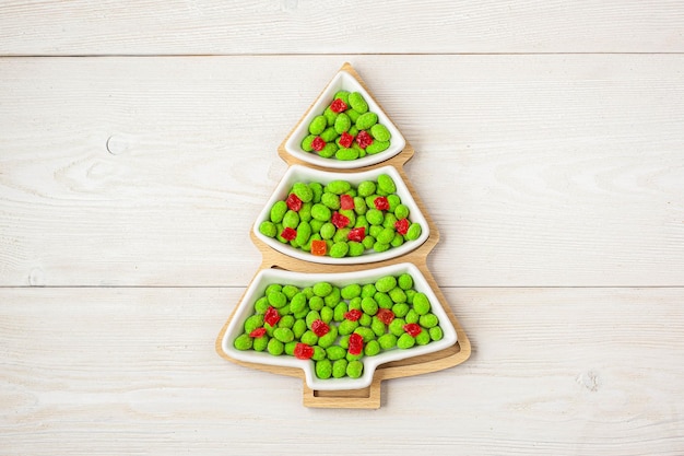 Foto dulces de navidad dulces en un plato en forma de árbol de navidad sobre un fondo de madera para lugar