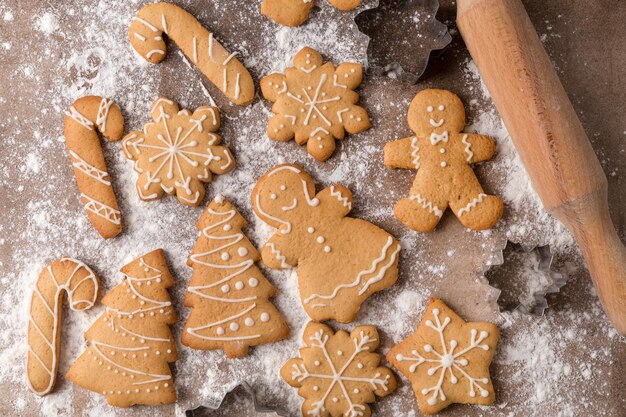 Dulces de Navidad, galletas de jengibre caseras y utensilios de cocina en la mesa marrón