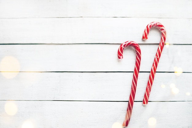 Dulces de Navidad con una guirnalda sobre un fondo de madera blanca