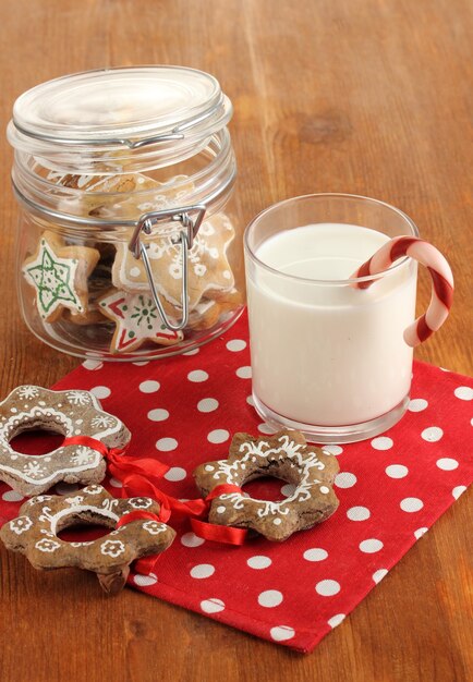 Dulces de Navidad y vaso de leche en primer plano de la mesa de madera