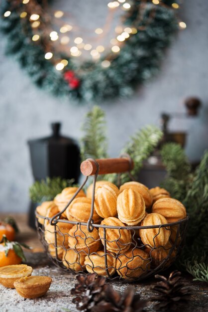 Dulces navideños galletas nueces con leche condensada en la mesa festiva, adornos navideños, enfoque selectivo