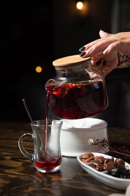 dulces orientales y té de frutas en una mesa de madera con un fondo oscuro