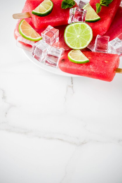 Dulces paletas de sandía y lima de verano con sandía en rodajas y menta