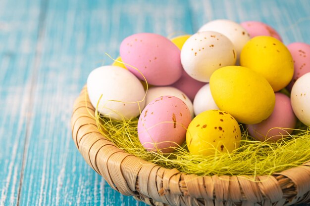 Dulces de Pascua coloridos huevos de chocolate en un nido de cerca