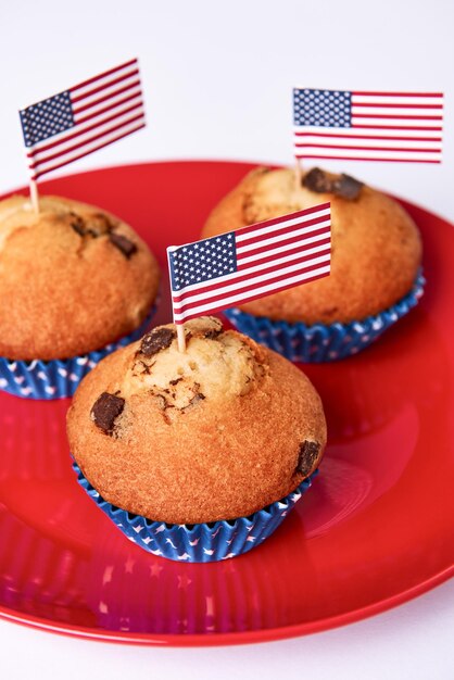 Foto dulces pasteles con bandera estadounidense en un plato rojo