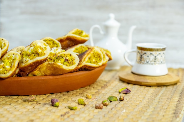 Dulces de ramadán qatayef con fondo blanco y tazas de café árabes